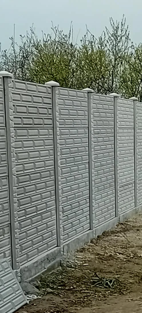Gard din panouri de beton cu model dreptunghiular, montat cu stâlpi și capace piramidale