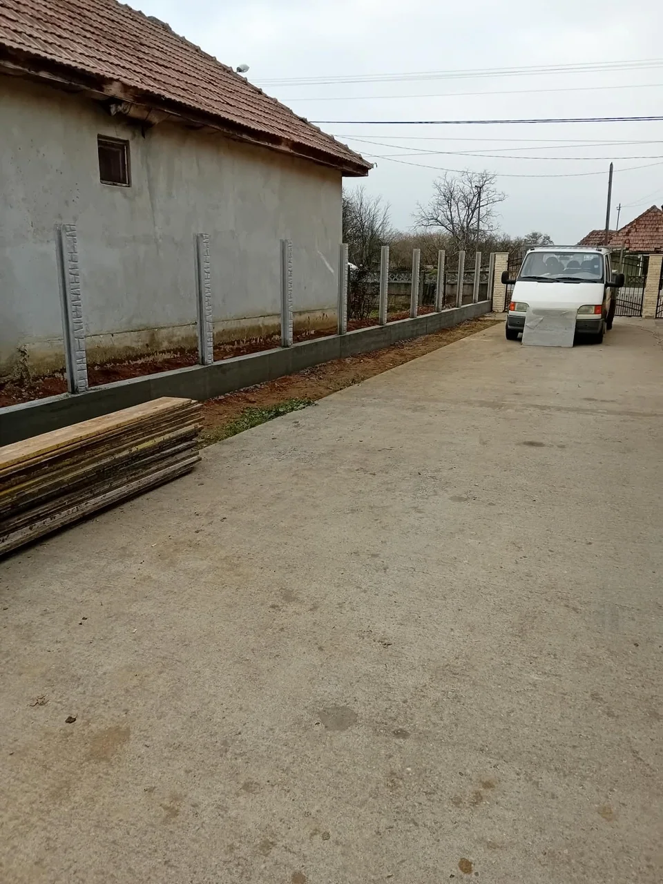 Stâlpi prefabricați din beton montați și aliniați pe o fundație continuă, înainte de introducerea panourilor
