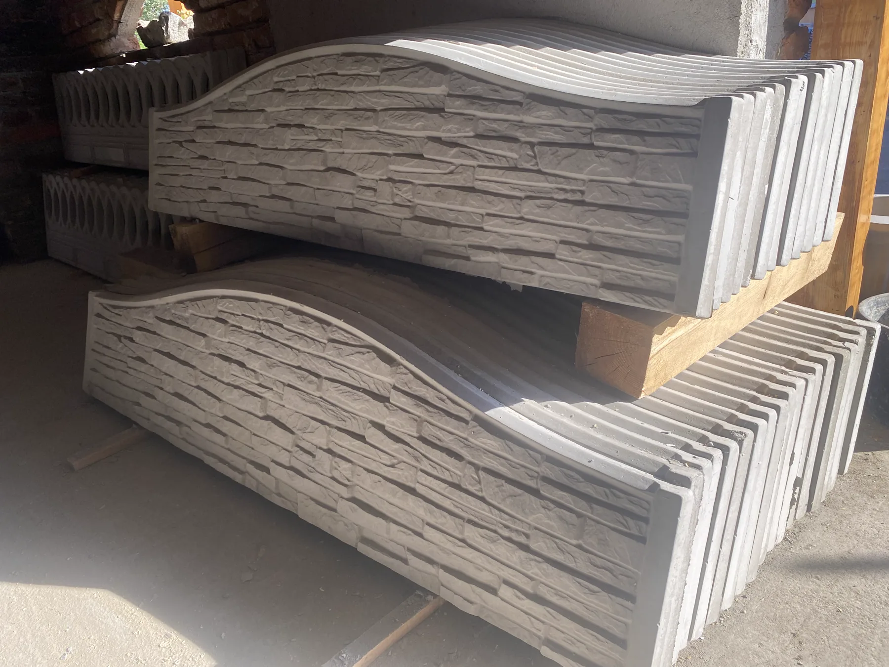 Panouri arcuite din beton cu textură de piatră aflate în depozit